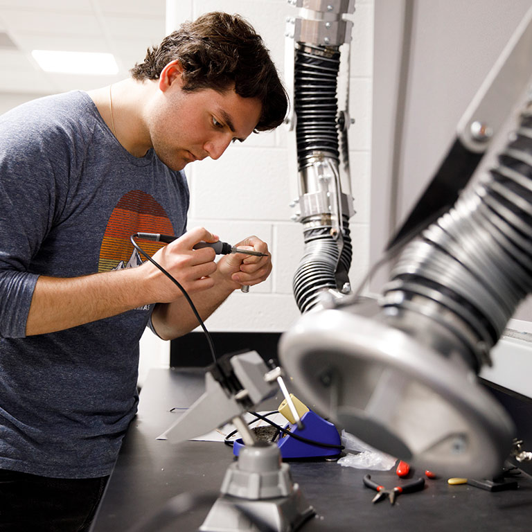 A student uses soldering equipment in a makerspace in Luddy Hall.