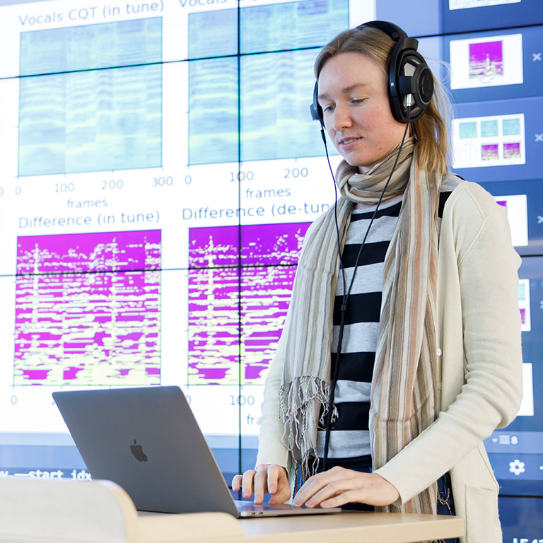Student Sanna Wager listens to music and interacts with a visualization in the Visualization Lab.